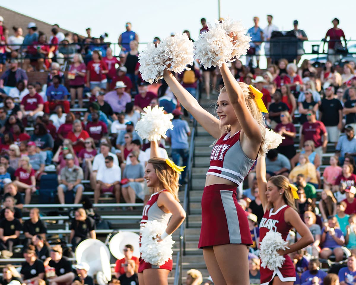 College cheerleader with pom-poms at the football game